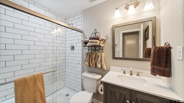 bathroom featuring toilet, vanity, and an enclosed shower