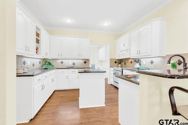 kitchen featuring white appliances, ornamental molding, white cabinetry, open shelves, and light wood-type flooring