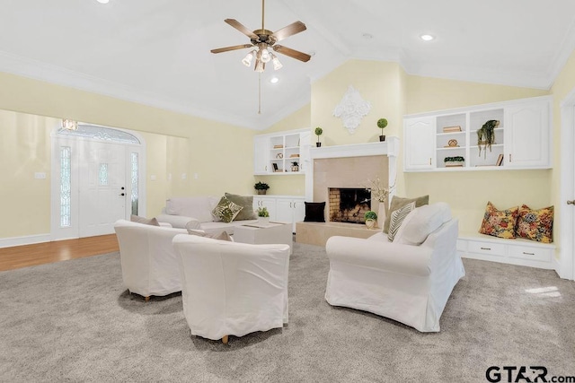 carpeted living area with high vaulted ceiling, a fireplace with raised hearth, wood finished floors, recessed lighting, and a ceiling fan