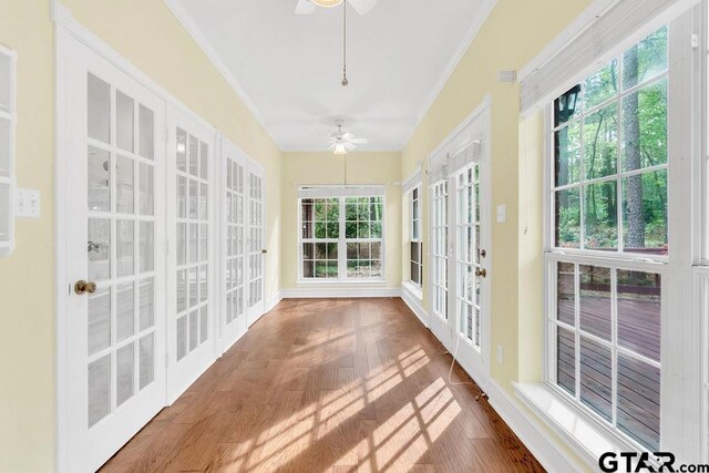 unfurnished sunroom with wood finished floors, french doors, and crown molding