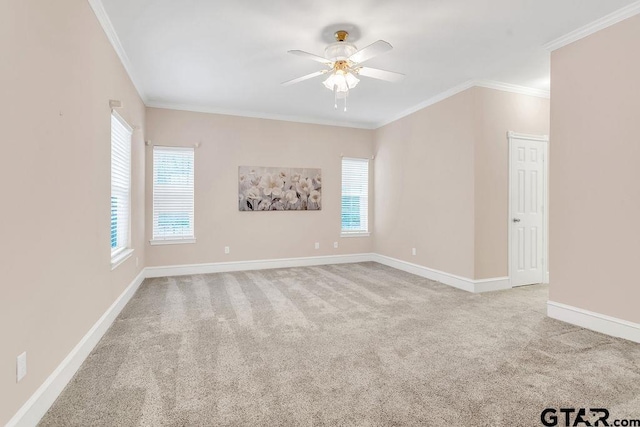 unfurnished room with carpet flooring, a ceiling fan, ornamental molding, and baseboards