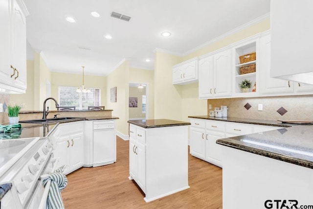 kitchen with light wood finished floors, white cabinetry, and stove