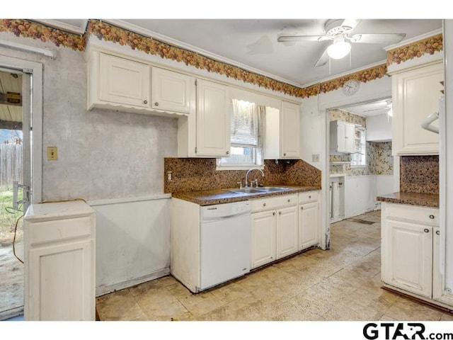 kitchen with dark countertops, ceiling fan, white dishwasher, white cabinetry, and a sink