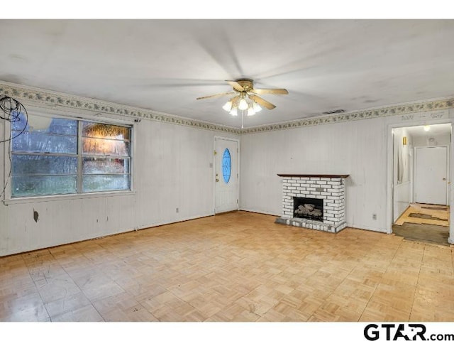 unfurnished living room with ceiling fan, a fireplace, and visible vents