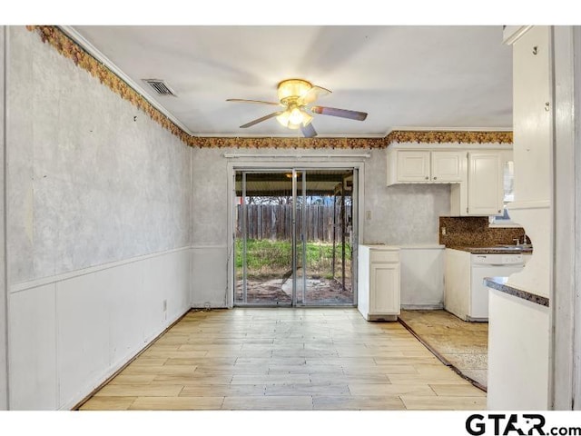 kitchen with white dishwasher, visible vents, white cabinetry, light wood-type flooring, and dark countertops