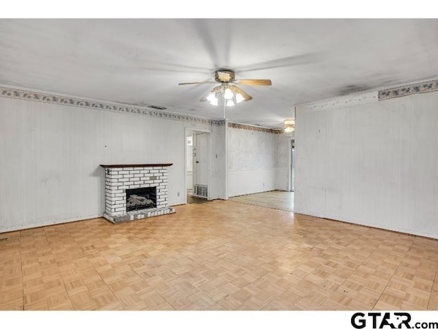 unfurnished living room with ceiling fan, a brick fireplace, and visible vents