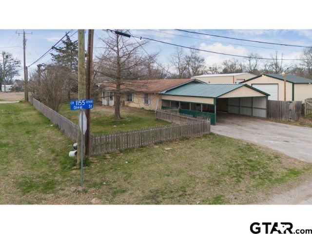 view of front facade with a carport, a fenced front yard, and a front yard