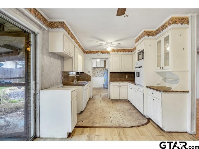 kitchen featuring ceiling fan, glass insert cabinets, white oven, light wood-style floors, and white cabinetry