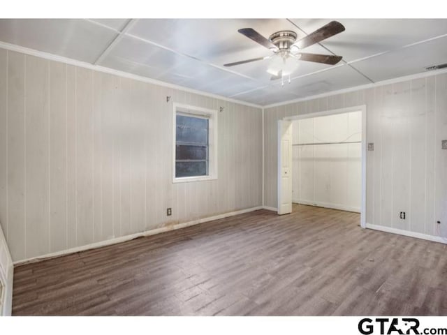 unfurnished bedroom featuring a ceiling fan, baseboards, visible vents, and wood finished floors