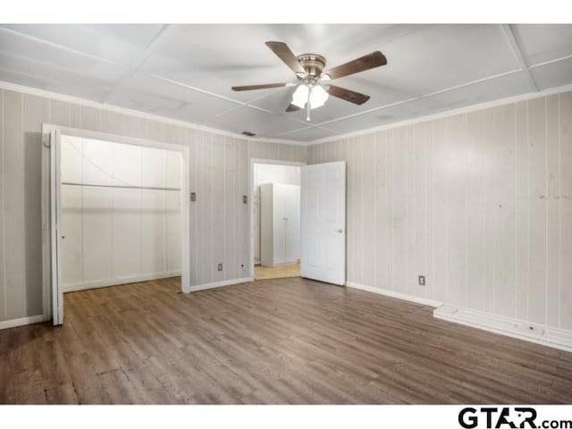 unfurnished bedroom with ceiling fan, ornamental molding, wood finished floors, and baseboards