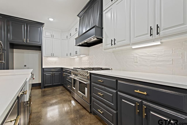 kitchen featuring white cabinets, range with two ovens, premium range hood, and tasteful backsplash