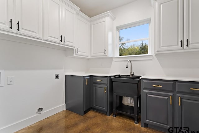 laundry room with electric dryer hookup and cabinets