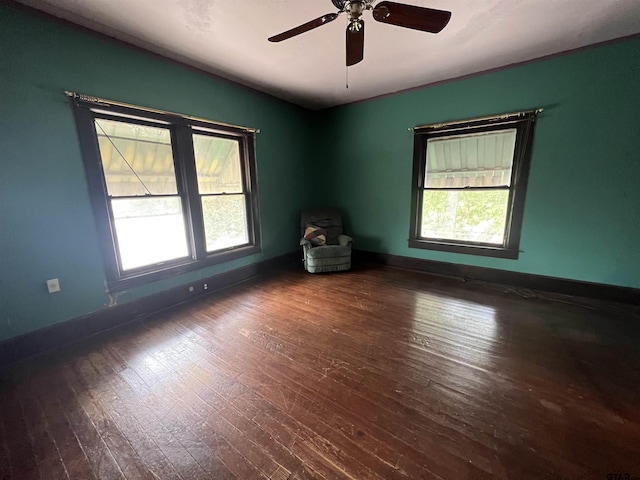 spare room with hardwood / wood-style flooring, baseboards, and a ceiling fan
