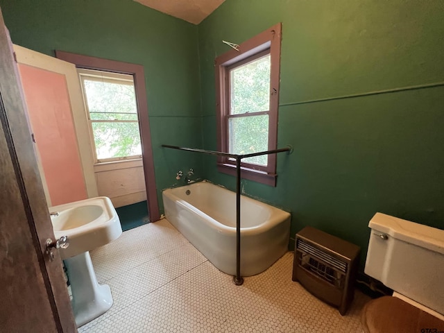 bathroom with toilet and a garden tub