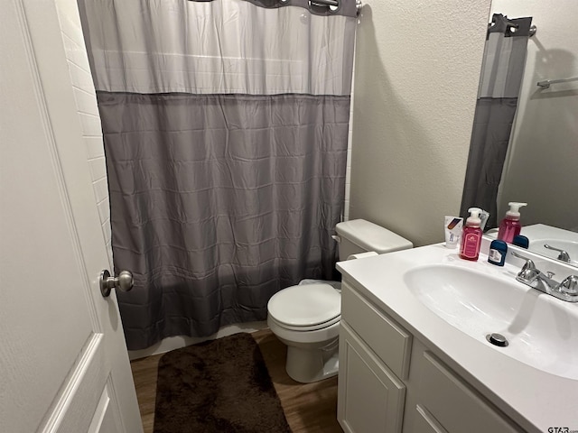 bathroom featuring vanity, toilet, wood-type flooring, and walk in shower