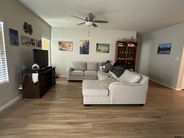 living room with wood-type flooring and ceiling fan