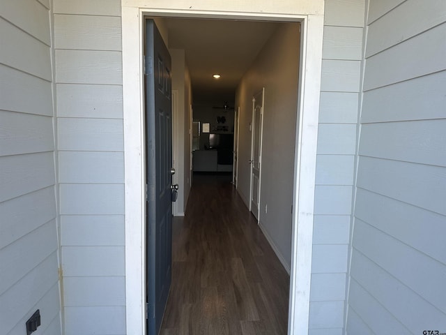 hallway featuring wooden walls and dark hardwood / wood-style floors