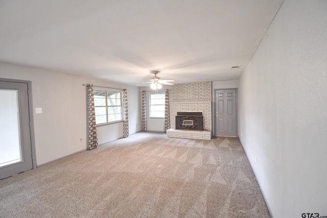 unfurnished living room with ceiling fan, visible vents, and light colored carpet