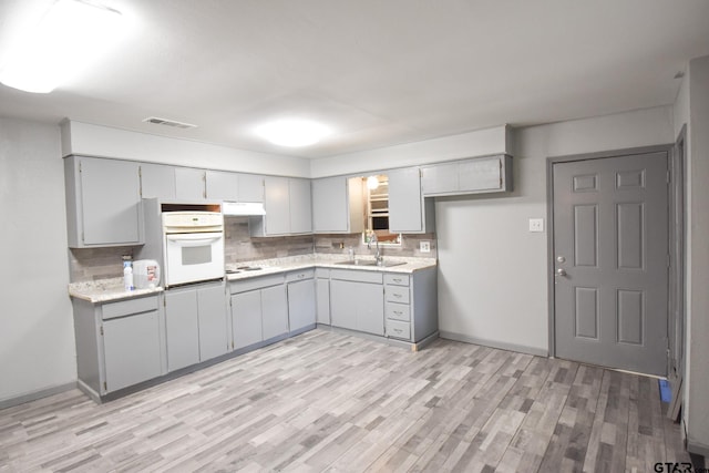 kitchen with white appliances, light countertops, and gray cabinetry