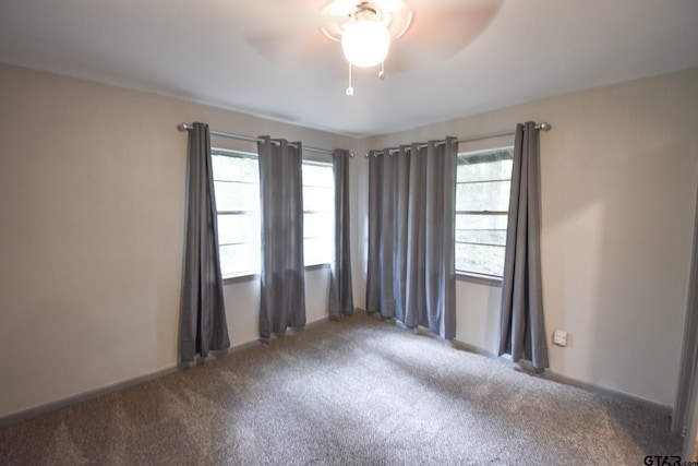 spare room with carpet, baseboards, ceiling fan, and a wealth of natural light