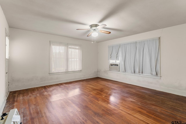 spare room with ceiling fan, cooling unit, and dark wood-type flooring