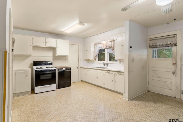 kitchen featuring black dishwasher, white stove, white cabinets, and sink