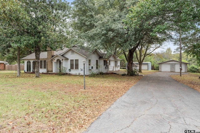 ranch-style home featuring a front yard, an outdoor structure, and a garage