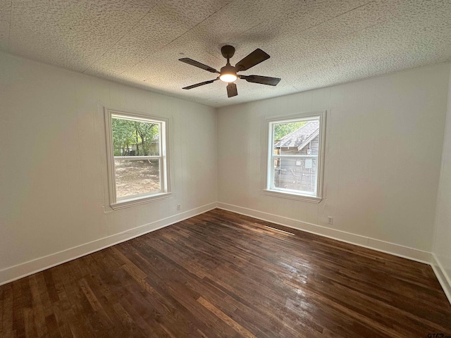 1409 W 3rd St, Tyler, TX 75701 - spare room featuring plenty of natural light, dark wood-style flooring, a ceiling fan, and a textured ceiling