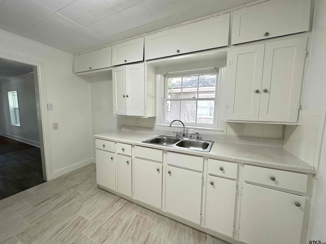 1409 W 3rd St, Tyler, TX 75701 - kitchen with white cabinets, light countertops, and light wood-style flooring