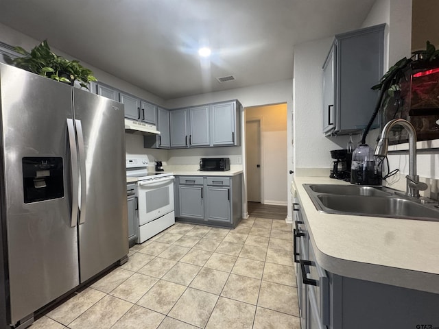 10845 Nashville Dr, Flint, TX 75762 - kitchen with stainless steel fridge, a sink, under cabinet range hood, white electric range, and black microwave
