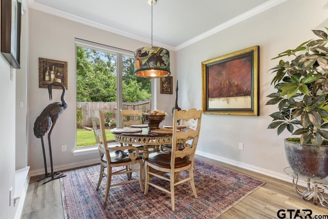 dining area featuring crown molding, plenty of natural light, and light hardwood / wood-style flooring