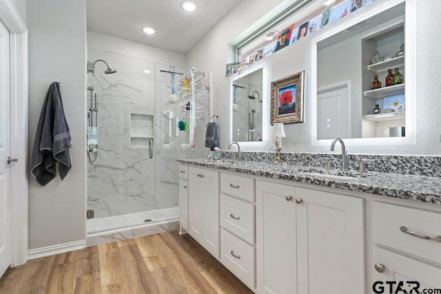 bathroom featuring vanity, wood-type flooring, and a shower with shower door