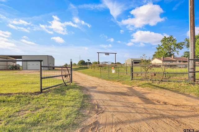 10708 C R 494, Tyler, TX 75706 - view of dirt / gravel road with a view of countryside, a gated entry, a gate, and an outbuilding
