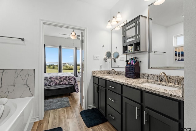 bathroom featuring ceiling fan, a bathtub, wood-type flooring, and vanity