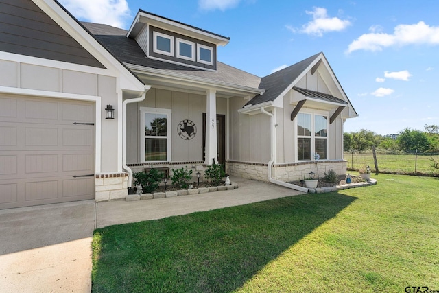 craftsman-style home featuring a porch, a front yard, and a garage