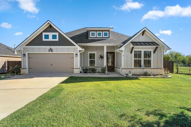 view of front of house featuring a front yard, a garage, and covered porch