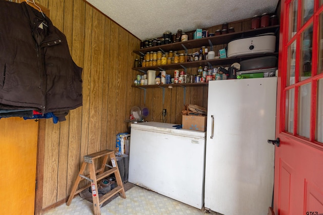 laundry room featuring a textured ceiling and wooden walls