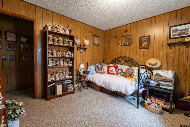 bedroom featuring wood walls and a textured ceiling