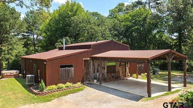 view of front of property featuring a carport, aphalt driveway, a front lawn, and central air condition unit