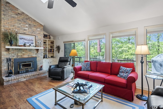 944 Clear Water Trl, Holly Lake Ranch, TX 75765 - living area with lofted ceiling, a ceiling fan, wood finished floors, a brick fireplace, and built in shelves