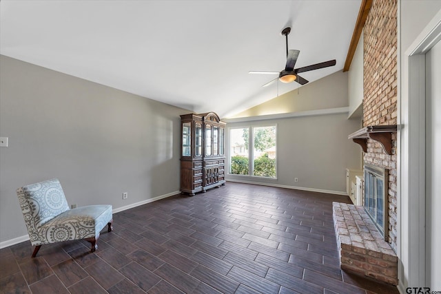 unfurnished room with lofted ceiling with beams, ceiling fan, dark hardwood / wood-style floors, and a brick fireplace