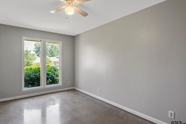 spare room featuring concrete floors and ceiling fan