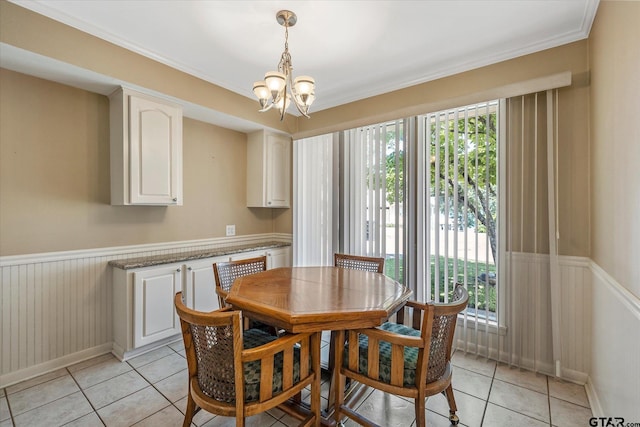 tiled dining area featuring crown molding and a notable chandelier