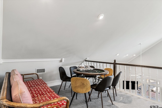 dining space featuring lofted ceiling, ornamental molding, and carpet flooring