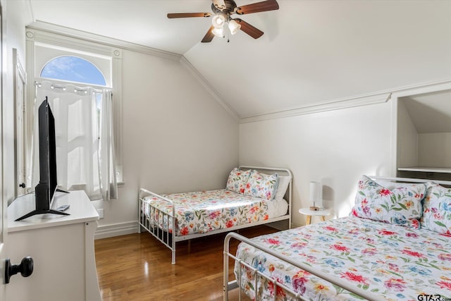 bedroom featuring ceiling fan, hardwood / wood-style floors, and vaulted ceiling