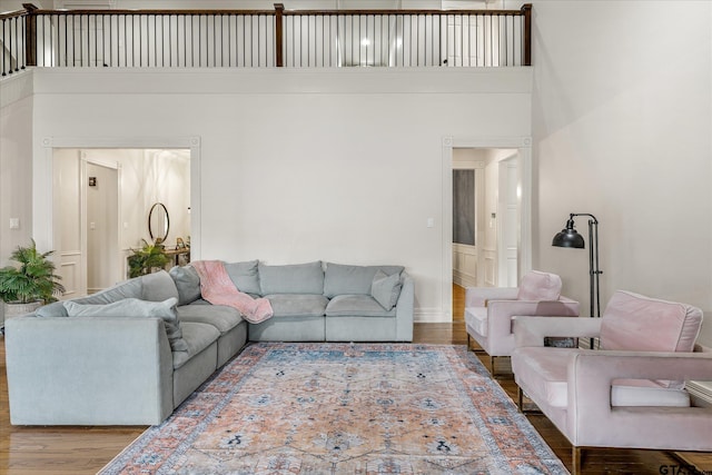 living room with hardwood / wood-style flooring and a towering ceiling