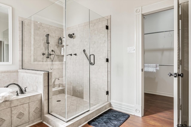 bathroom featuring shower with separate bathtub and wood-type flooring