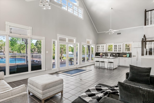 living room with high vaulted ceiling, ceiling fan, french doors, and dark tile patterned floors