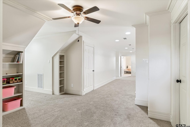 bonus room featuring ceiling fan, built in shelves, and light carpet