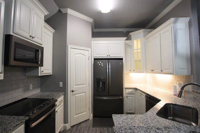 1700 Easy St, Tyler, TX 75703 - kitchen with black appliances, crown molding, white cabinetry, decorative backsplash, and light stone counters